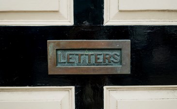 Close-up of metal letterbox in door