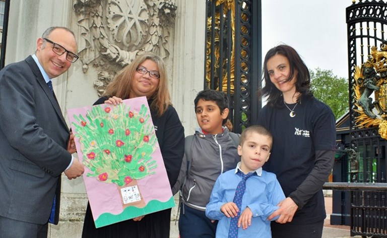 Children from Camden Short Breaks deliver a birthday card to Buckingham Palace