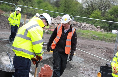 A young person on site with a training manager