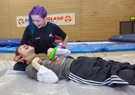 Young person being assisted on a trampoline
